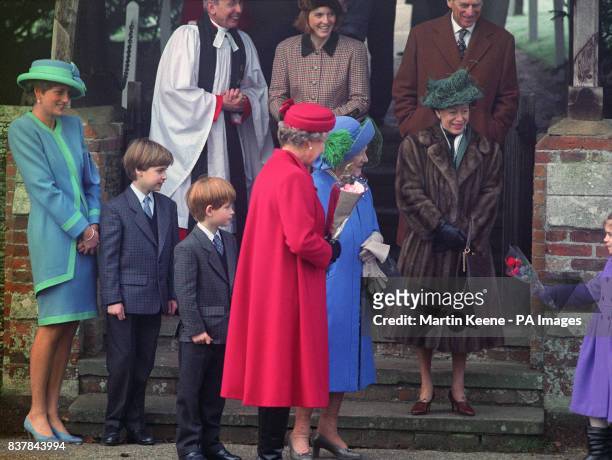The Queen Mother is presented with a bouquet after attending a Christmas morning service at Sandringham Church. With the Queen Mother are Diana,...