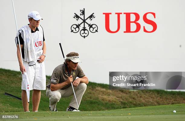 Bernhard Langer of Germany lines up his putt with his caddy, and son, Stefan Langer on the 18th hole during the third round of the UBS Hong Kong Open...