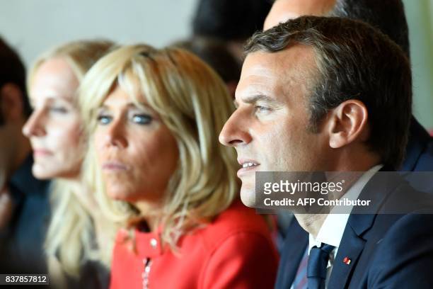 French President Emmanuel Macron and his wife Brigitte Macron listen in during a piano masterclass by French pianist Dominique Merlet on August 23,...