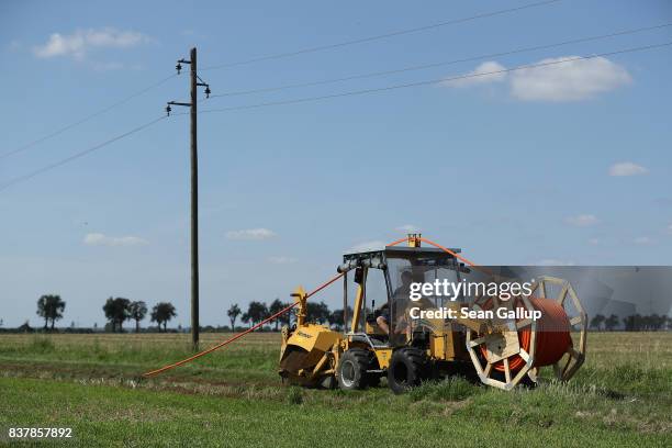 Worker drives a specialzed vehicle that is laying tubing used for running fiber optic cable underground during the installation of broadband...