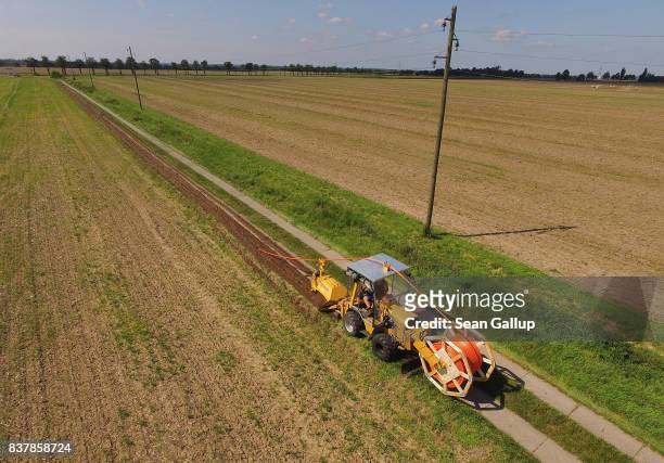 In this aerial view a worker drives a specialzed vehicle that is laying tubing used for running fiber optic cable underground during the installation...