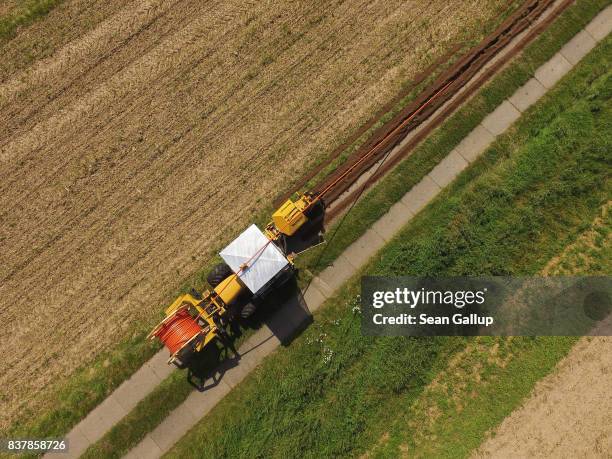 In this aerial view a worker drives a specialzed vehicle that is laying tubing used for running fiber optic cable underground during the installation...