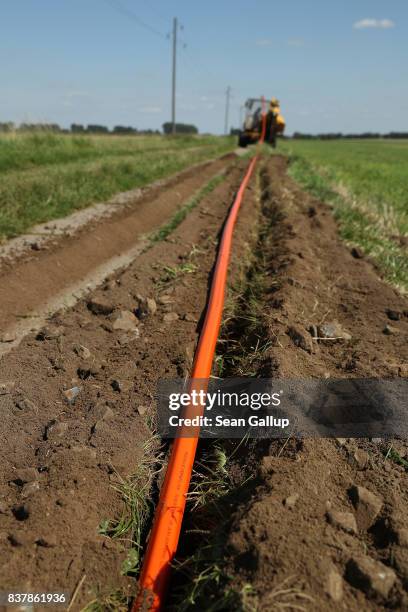 In this aerial view a worker drives a specialzed vehicle that is laying tubing used for running fiber optic cable underground during the installation...