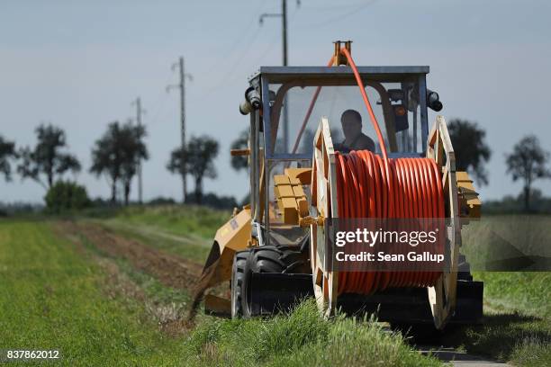 In this aerial view a worker drives a specialzed vehicle that is laying tubing used for running fiber optic cable underground during the installation...