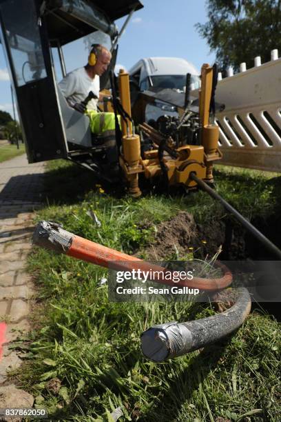 Worker uses a specialized drilling vehicle for digging a horizontal hole to accomodate tubing used for laying fiber optic cable underground during...