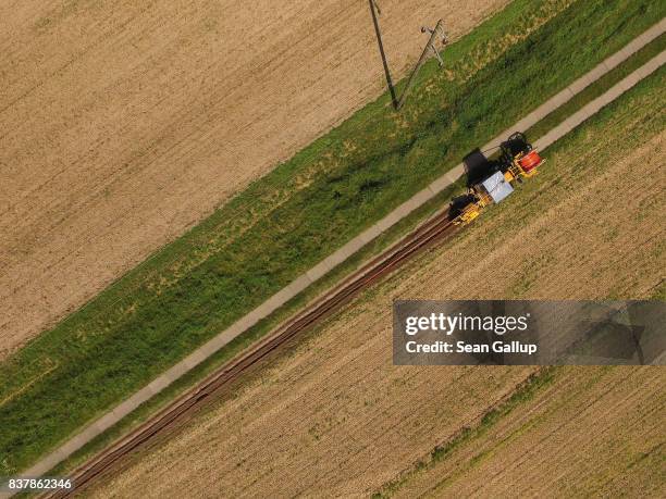 In this aerial view a worker drives a specialzed vehicle that is laying tubing used for running fiber optic cable underground during the installation...