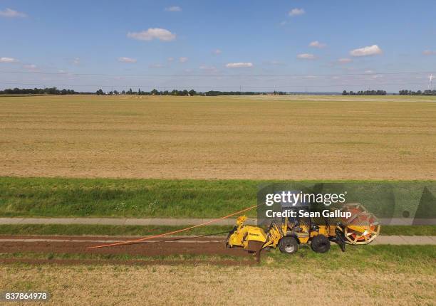 In this aerial view a worker drives a specialzed vehicle that is laying tubing used for running fiber optic cable underground during the installation...