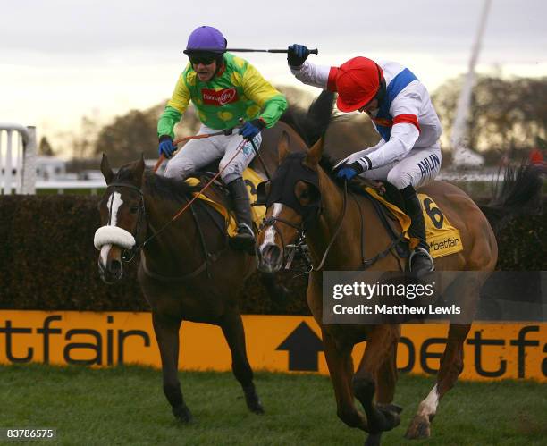 Kauto Star ridden by Sam Thomas falls at the last fence, as Tamarinnbleu ridden by T.J.O'Brien leads in the Betfair Steeple Chase Race at Haydock...