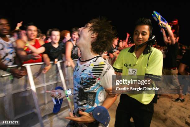 Graduating year 12 students is escorted by a security guard during the opening night celebrations of Schoolies week in Surfers Paradise on November...