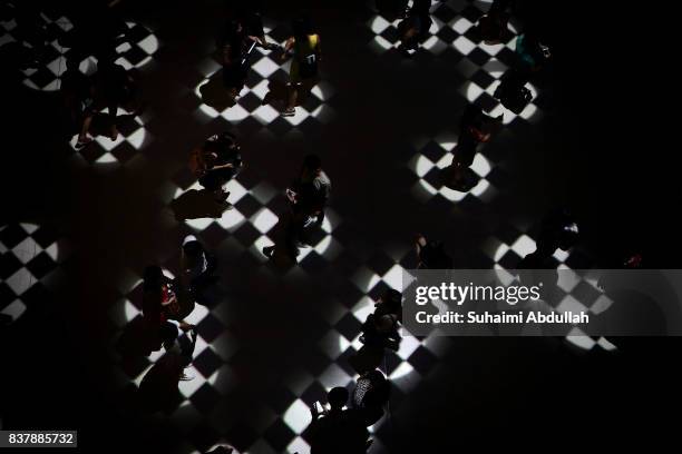 Visitors interact with light projections entitled 'Flock' by UK artists Tom Wexler and Kit Monkman during the Singapore Night Festival media preview...