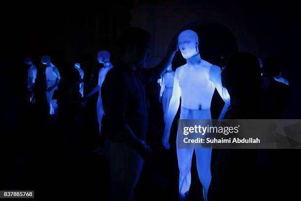 Visitors interact with an art installation of human sized figurines, 'The Standing Men' by AADN of France during the Singapore Night Festival media...