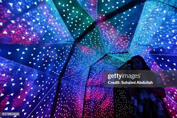 Visitors walk through a light installation entitled 'Phosphene' By Praxis+, a team from the Singapore University of Technology and Design during the...