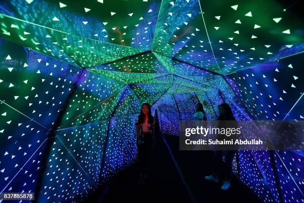 Visitors walk through a light installation entitled 'Phosphene' By Praxis+, a team from the Singapore University of Technology and Design during the...