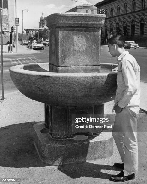 Back at Original Site Ron Sena of 1009 W. 14th Ave., looks over a turn- of-the-century-style granite drinking fountain for dogs and horses after it...