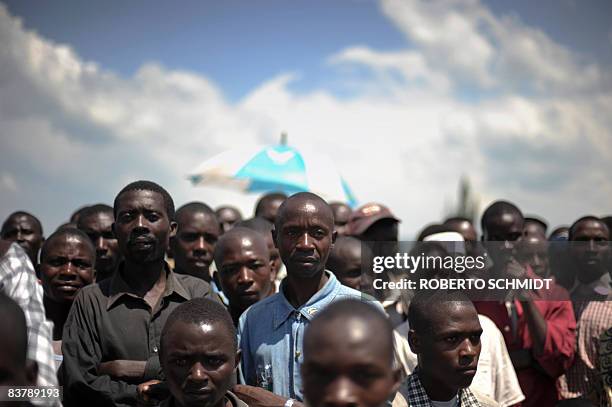 Locals listen to rebel leader Laurent Nkunda at the local stadium in the North Kivu town of Rutshuru on November 22, 2008. About 500 people packed...