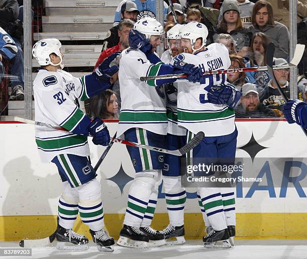 Daniel Sedin of the Vancouver Canucks is congratulated on his second period goal by Henrik Sedin, Mattias Ohlund and Lawrence Nycholat while playing...