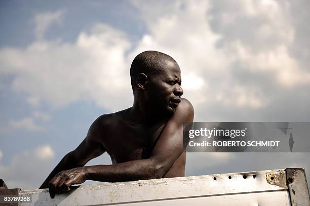 Congolese man rides the back of a truck as it was stopped near where rebel leader Laurent Nkunda was speaking with local leaders at a house in the...