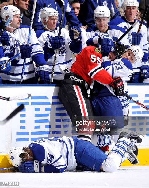 Alexei Ponikarovsky of the Toronto Maple Leafs fights with Ben Eager of the Chicago Blackhawks as team mate Mikhail Grabovski lies injured on the ice...