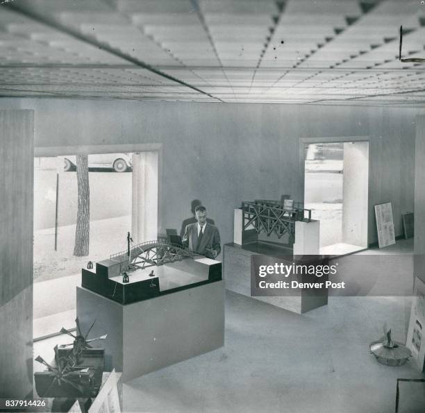 Otto Karl Bach, director of the Denver Art museum, stands beside a model of one of Leonardo Da Vinci's inventions in the new Schleier memorial branch...