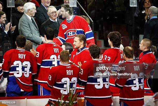 Members of the Montreal Canadiens look on as Patrick Roy shakes hands with Jean Beliveau as the Montreal Canadiens honoured Patrick Roy by retiring...