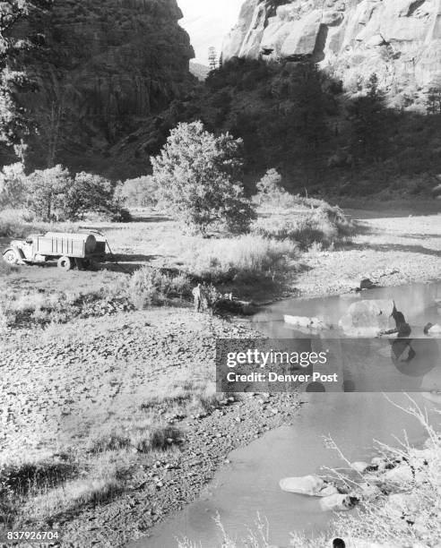 Dove Creek workmen pump water from this stagnant pool in the Dolores river and truck it to the tiny southwestern Colorado community. The hole is the...