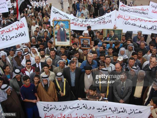 Iraqi men and tribal leaders march along a street in the town of Khalis some 20kms west of the northeastern city of Baquba on November 23 2008, to...