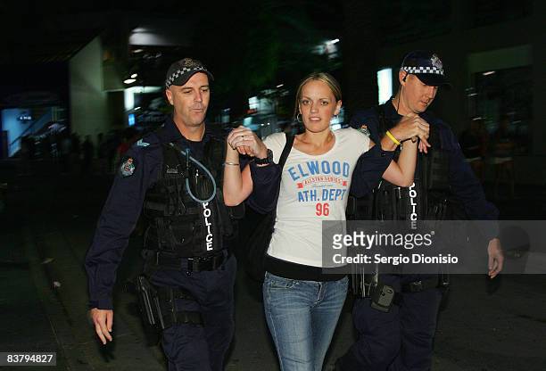 Police officers arrest a young school leaver during the Schoolies week celebrations in Surfers Paradise on November 23, 2008 on the Gold Coast,...