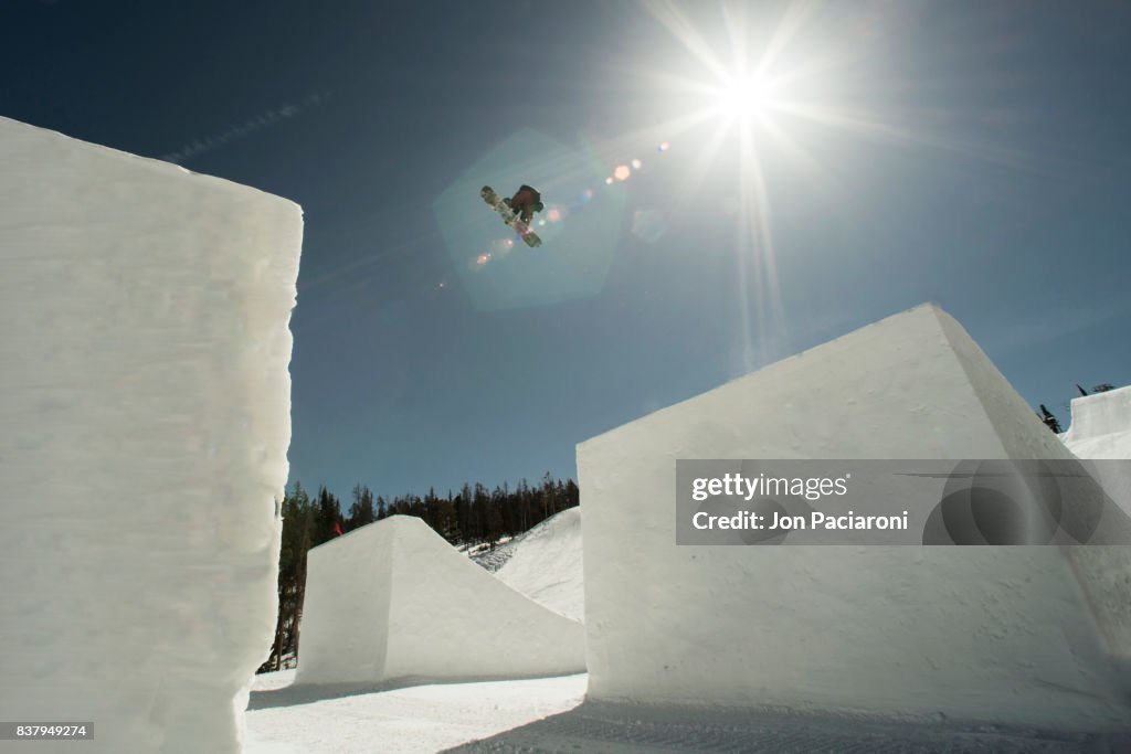 Female Snowboarder getting big air off of a massive jump
