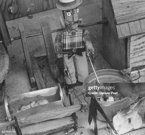 Gragg, F.M. - Toy Mechanic A farmer operates butter churn, rocks a baby and washes clothes, all at same time. Credit: Denver Post