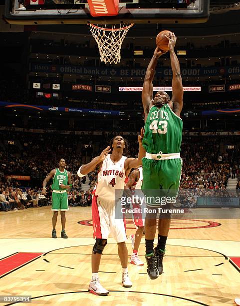 Kendrick Perkins of the Boston Celtics shoots the layup ahead of Chris Bosh of the Toronto Raptors on November 23, 2008 at the Air Canada Centre in...