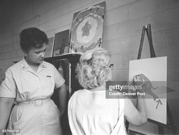 Mrs. Jeannette Foco views a painting being completed by an inmate. Mrs. Foco says some of the inmates are extremely talented, including this one....