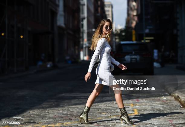 Rosa Crespo is seen in Soho wearing a Naked Wardrobe white dress, Chiara Ferragni Collection gold boots and Laurencecchi backpack on August 22, 2017...
