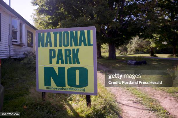 Anti-national monument sign sits in a front lawn near the Route 11 entrance into Katahdin Woods and Waters National Monument.