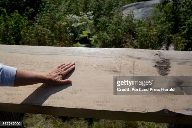 Jennifer Fitzpatrick, of Durham, touches the engravings of the mountains seen from a scenic view point at Stop 6 on Loop Road at Katahdin Woods and...