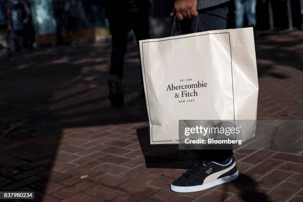 Shopper carries an Abercrombie & Fitch Co. Bag while walking on Market Street in San Francisco, California, U.S., on Tuesday, Aug. 22, 2017....