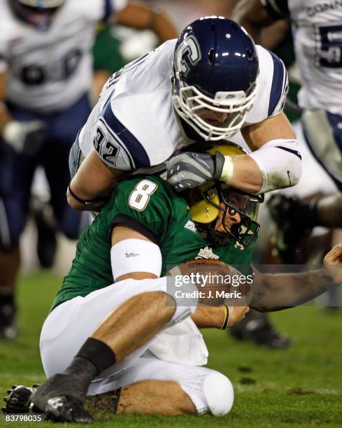 Quarterback Matt Grothe of the South Florida Bulls is sacked by linebacker Scott Lutrus of the Connecticut Huskies during the game at Raymond James...