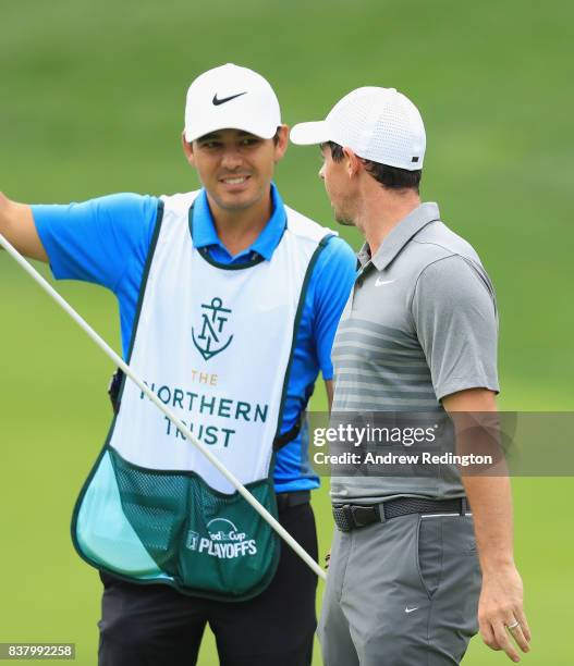 Rory McIlroy of Northern Ireland is pictured with his caddie Harry Diamond during practice for The Northern Trust at Glen Oaks Club on August 23,...