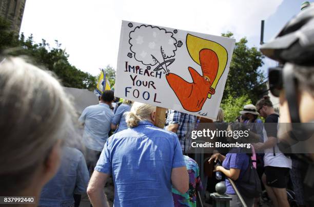 Demonstrator holds a sign that reads "Impeach Your Fool" during an anti-racism rally in front of the U.S. Embassy in Ottawa, Ontario, Canada on Aug....