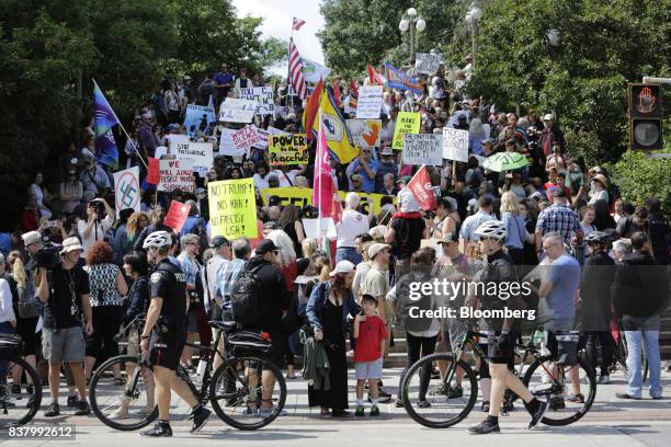 Demonstrators hold signs and wave flags during an anti-racism rally in front of the U.S. Embassy in Ottawa, Ontario, Canada on Aug. 23, 2017. The...