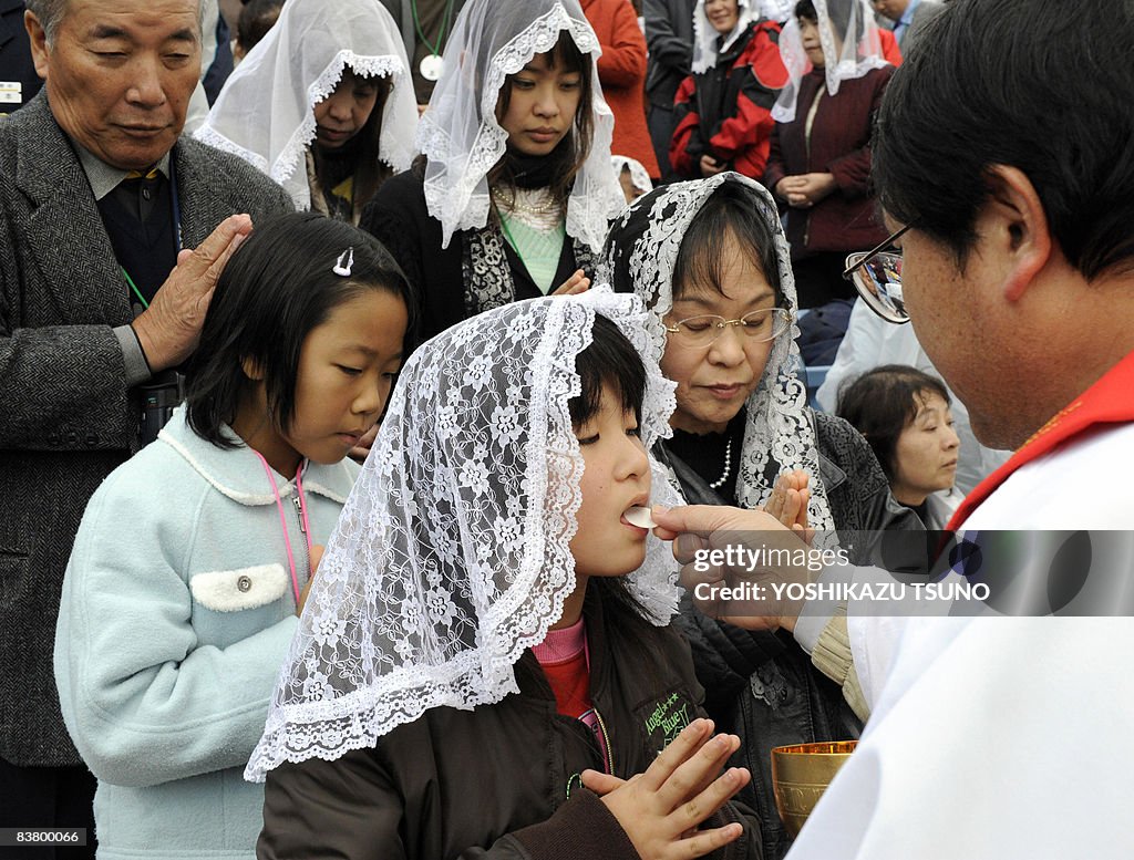 A girl receives the communion from a Jap
