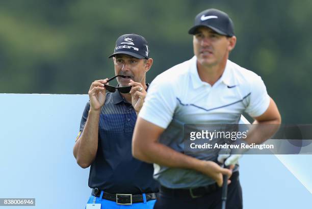 Claude Harmon III, golf caoch, watches Brooks Koepka of the USA during practice for The Northern Trust at Glen Oaks Club on August 23, 2017 in...