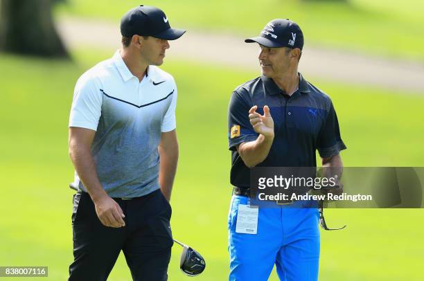 Brooks Koepka of the USA walks with his coach Claude Harmon III during practice for The Northern Trust at Glen Oaks Club on August 23, 2017 in...