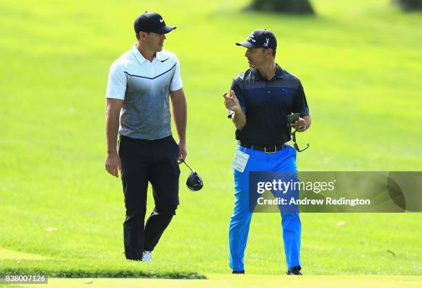 Brooks Koepka of the USA walks with his coach Claude Harmon III during practice for The Northern Trust at Glen Oaks Club on August 23, 2017 in...