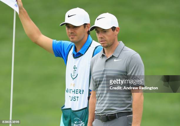Rory McIlroy of Northern Ireland is pictured with his caddie Harry Diamond during practice for The Northern Trust at Glen Oaks Club on August 23,...