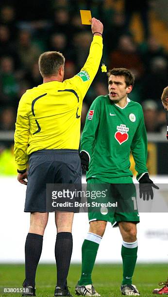 Referee Dr. Helmut Fleischer shows the yellow card to Zvjezdan Misimovic during the Bundesliga match between VfL Wolfsburg and VfB Stuttgart at the...