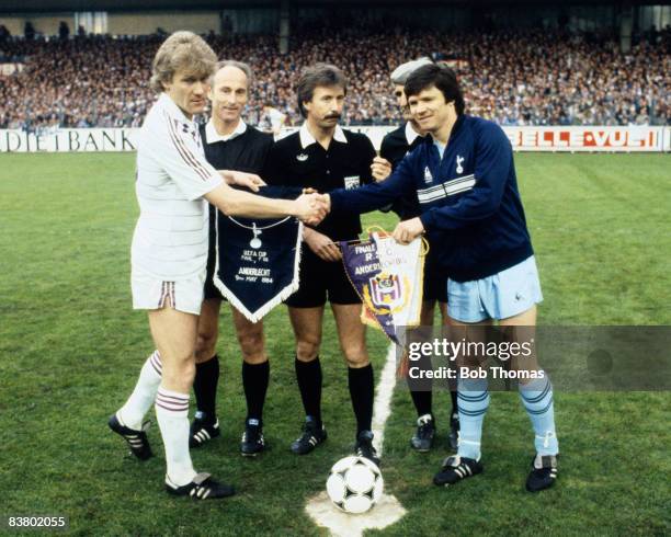 Tottenham Hotspur captain Steve Perryman and Andrelecht's Morten Olsen exchange pennants before the UEFA Cup Final 1st leg in Brussels, watched by...