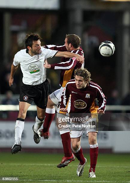 Clint Easton of Hereford United heads the ball under pressure from Liam Dolman and Ryan Gilligan of Northampton Town during the Coca Cola League One...
