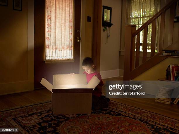 boy looking into box with light illuminating out - open day 6 stock pictures, royalty-free photos & images