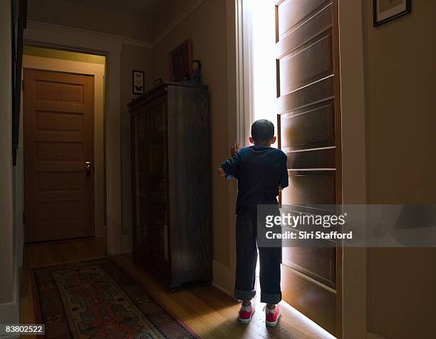 boy peeking into room with light coming out - peer bildbanksfoton och bilder