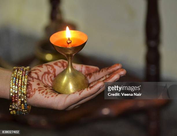 a young girl holding lighted oil brass lamp/diwali - diya oil lamp stockfoto's en -beelden